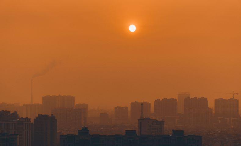 Orange glow at sunset in polluted city.